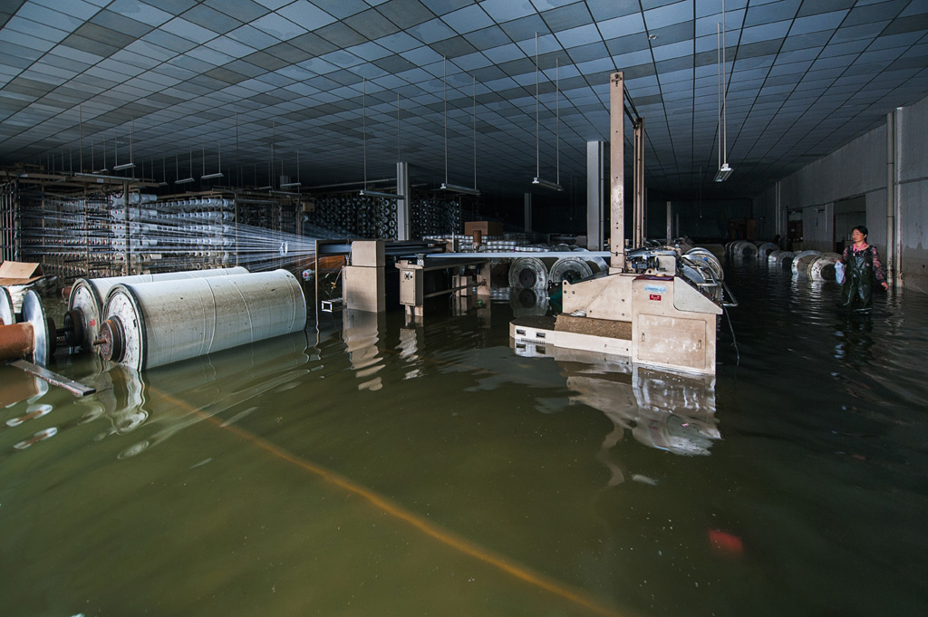 3、工厂被淹，车间内的机器、原料、成品在水中，工厂负责人站在水中一筹莫展，拍摄于2.jpg
